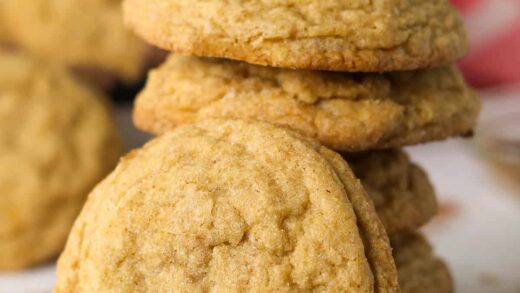 A stack of pumpkin sugar cookies on a countertop.