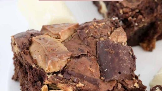 A close up of square of brownie slice with chunks of white and dark chocolate baked on top.