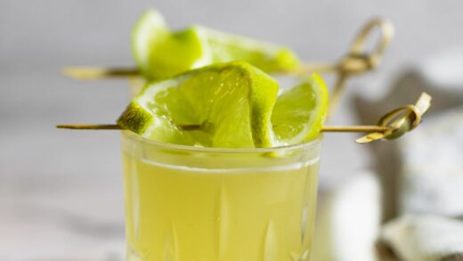 green tea shot garnished with lime slices