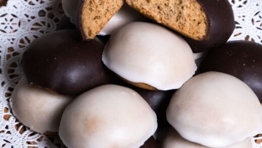 A wicker basket with a doilie holds black and white glazed Pryaniki cookies.