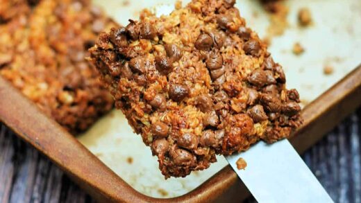 A square of flapjack being lifted out of a pan on a spatula.