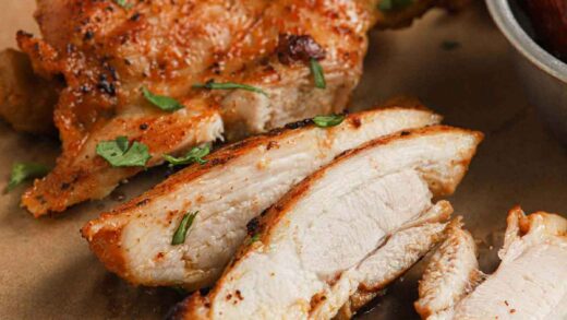 Cooked Chipotle chicken sliced and on a cutting board.