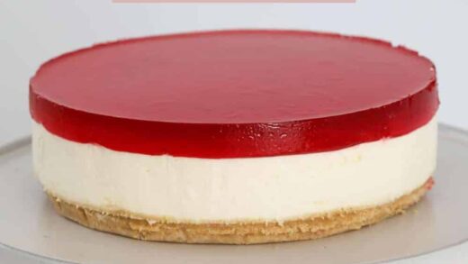 A jelly cheesecake on a cake stand.