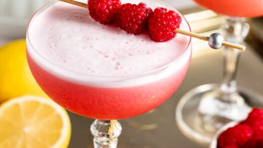 two glasses on gold tray with raspberries