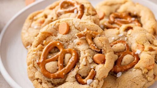 Four salted caramel pretzel cookies arranged on a white plate.