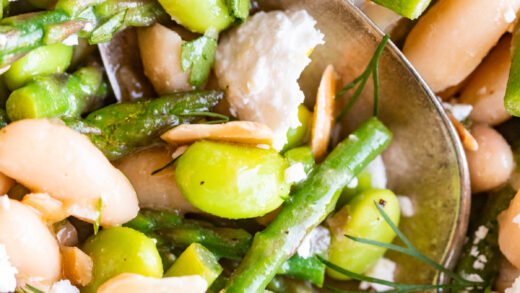 spoonful of spring salad with edamame, asparagus, cannellini beans, slivered almonds, and crumbled cheese