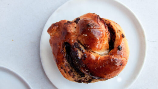 overhead shot of 3 chocolate babka rolls on white plates