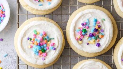 frosted sugar cookies with sprinkles on a wire rack