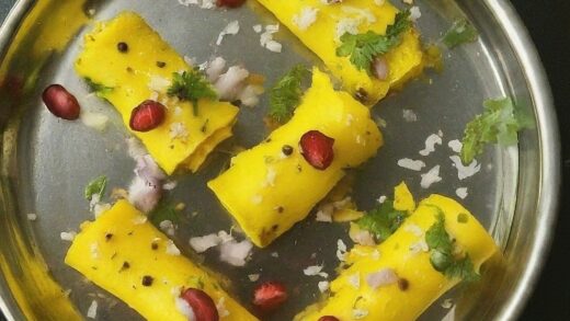 A close-up of rolled Khandvi, a savoury vegan Indian snack made from gram flour batter.