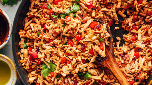 Stirring a skillet of vegan shredded tofu taco meat