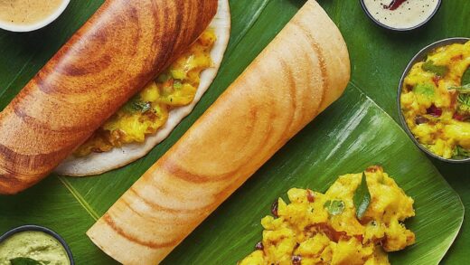 A delicious masala dosa served with coconut chutney and sambar on a banana leaf