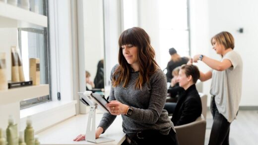 woman in gray sweater holding tablet computer