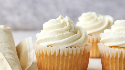 piping chantilly cream frosting onto cupcakes