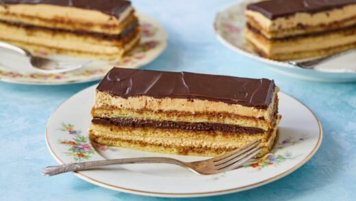 Three slices of This Classic Opera Cake are served, featuring layers of sponge cake, coffee syrup, French coffee buttercream, and chocolate butter glaze.