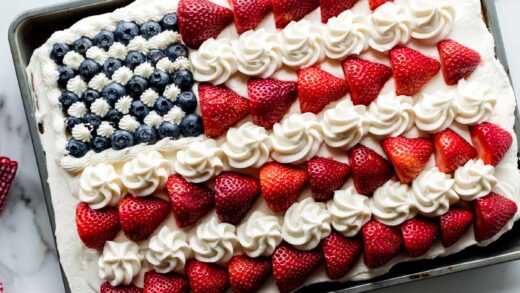 vanilla sheet cake decorated like an American flag with berries and frosting