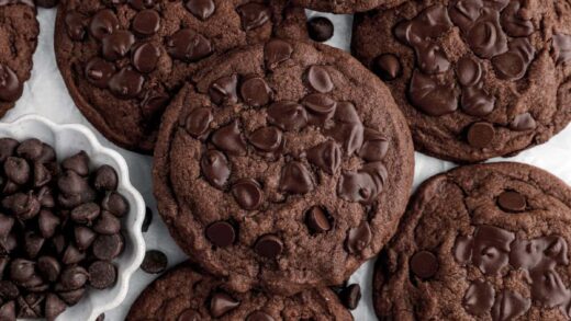 double chocolate chip cookies piled on parchment paper.