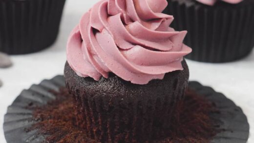 rich chocolate cupcakes with piped pink buttercream frosting swirl topping.