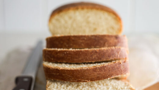 Sourdough buttermilk bread, sliced, with a bread knife.