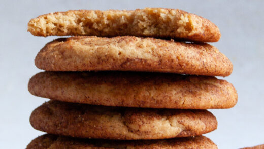 Straight on macro shot of cinnamon peanut snickerdoodles with bite taken out of top cookie