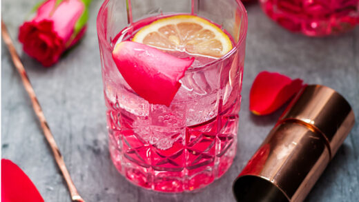 Rose Vodka Tonic Mixed Drink Cocktail - above view of cocktail in rocks glass with rose, jigger and stirrer surrounding, square cropped