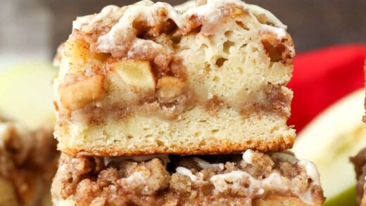 Side view of a two apple coffee cake slices stacked on top of one another.